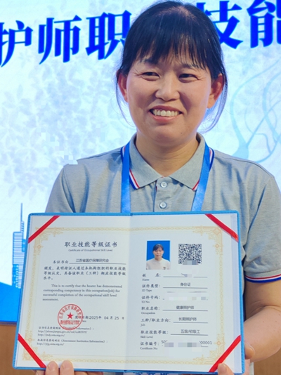 4月28日，长期照护师代表展示自己的“000001”编号证书。摄影/郭晋晖